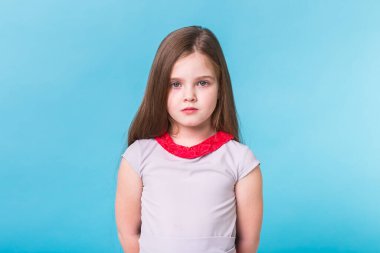 Mavi arka planda izole edilmiş güzel küçük bir kız. Çocukluk ve çocuk kavramı.