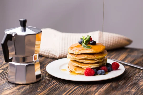 Vrouw gieten esdoorn siroop op smakelijke pannenkoeken. — Stockfoto