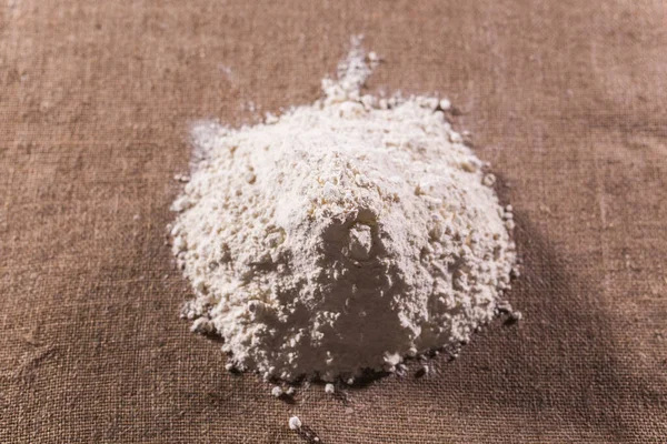 직물 위에 마른 밀가루를 쌓아 올려 놓는다. 밀가루 제품 요리 개념. — 스톡 사진