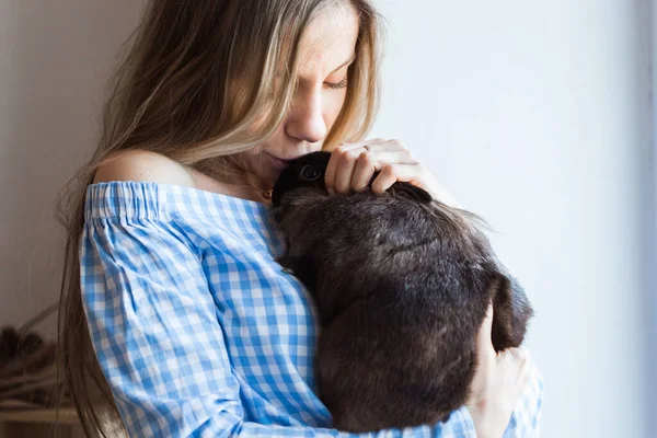 Mascotas y concepto de Pascua - Muchacha atractiva abrazando conejo marrón en casa, primer plano . — Foto de Stock