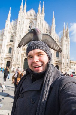 Seyahat, İtalya ve eğlence konsepti - Mutlu turist Duomo Katedrali önünde güvercinlerle kendi portresini çekiyor, Milano