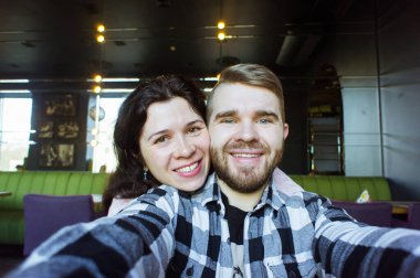 Sevgi dolu bir çift kafede selfie çekiyor. Teknoloji ve fotoğraf konsepti.