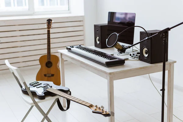 Micrófono, ordenador y equipo musical guitarras y fondo de piano. concepto de estudio de grabación en casa . —  Fotos de Stock