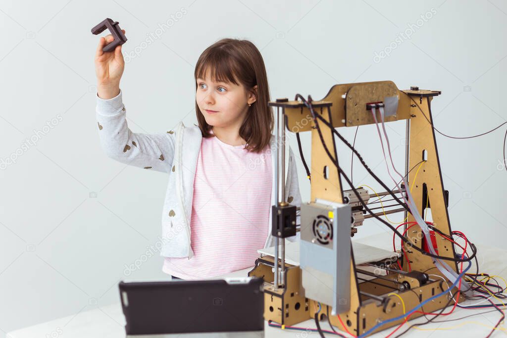 Child student makes the item on the 3D printer. School, technologies and science concept.