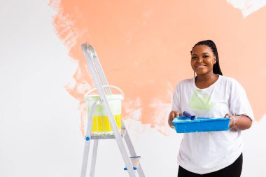 Kapalı alanda paten çizen güzel, Afro-Amerikan bir kadın. Dekorasyon, yenileme, apartman onarımı ve ferahlatıcı konsept.
