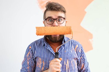 Duvarı boyayan komik adam. Yenileme, dekorasyon ve onarım konsepti.