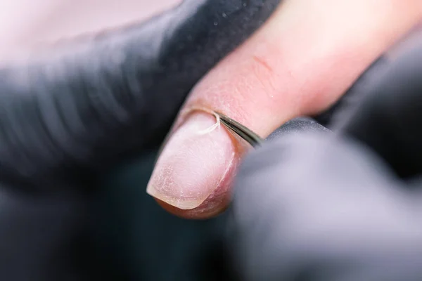 Close-up tiro de manicure hardware em um salão de beleza. Manicure está aplicando broca de arquivo de unhas elétrica para manicure em dedos femininos . — Fotografia de Stock