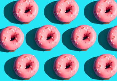 Moda güneş ışığı. Açık mavi turkuaz arka planda pembe donutla yapılmış yaz deseni. Minimum yaz konsepti. Pop sanat tarzı. Çörek.
