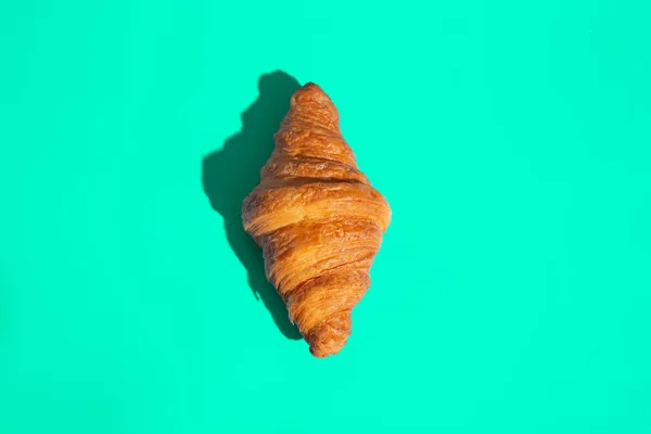 Bakery products baked croissant. Green background, top view. Pop art style. Delicious and food concept. — Stock Photo, Image