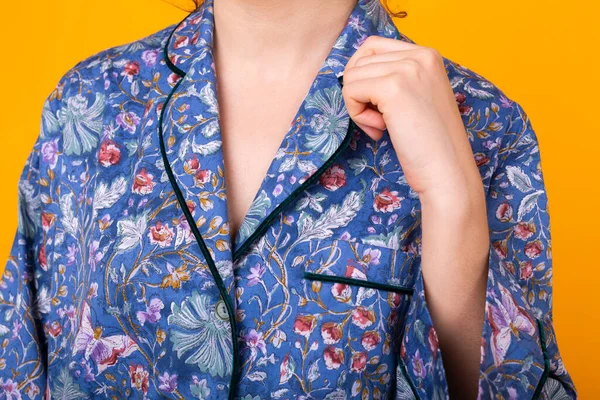 Close-up van meisje in huis dragen pyjama over kleurrijke gele achtergrond. — Stockfoto