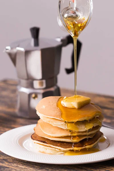 Männliche Hand gießt Ahornsirup auf leckere Pfannkuchen. — Stockfoto