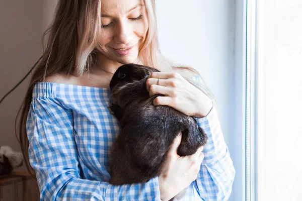 Mascotas y concepto de Pascua - Muchacha atractiva abrazando conejo marrón en casa, primer plano . — Foto de Stock