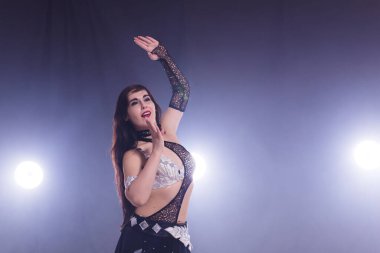 Göbek dansçısı. Genç ve çekici bir kadın sahnede dans ediyor. Doğulu egzotik dans. Boşluğu kopyala.