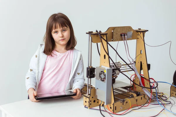 Linda chica con persianas impresas en 3D está viendo su impresora 3d, ya que imprime su modelo 3d . — Foto de Stock