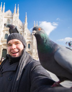 Seyahat, İtalya ve eğlence konsepti - Mutlu turist Duomo Katedrali önünde güvercinlerle kendi portresini çekiyor, Milano