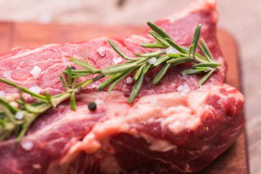 Tahta kesme tahtasındaki biftek için taze çiğ et, yakın plan..