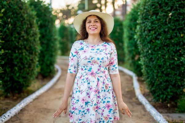 Portret van een mooie vrouw in witte jurk en strohoed op zonnige warme weerdag. Wandelen in het zomerpark. — Stockfoto