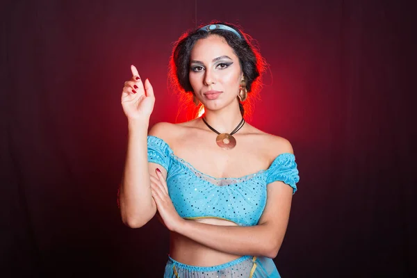 Magie, cosplay, carnaval en sprookjesconcept - Portret van een jonge vrouw in het beeld van een Oosterse sprookjesprinses op donkere achtergrond. — Stockfoto