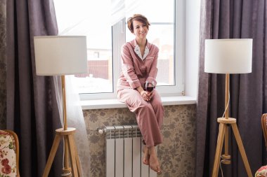 Genç esmer kadın evde kırmızı şarapla rahatlıyor. Karantina, izolasyon, koronavirüs salgını. Evde kal..