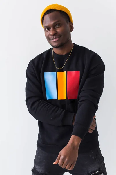 Portrait handsome young black man dressed in jeans and sweatshirt on white background. Street fashion and modern youth culture. — Stock Photo, Image