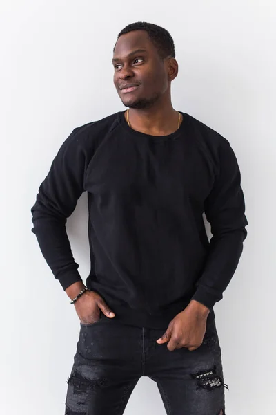 白い背景に黒いスウェットシャツを着たハンサムなアフリカ系アメリカ人男性。若者のストリートファッション写真とともにアフロヘアスタイル. — ストック写真