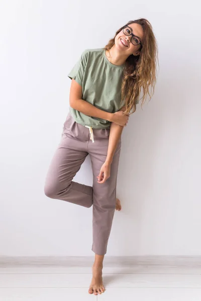 Mujer atractiva joven vestida con hermoso pijama colorido posando como modelo en su sala de estar. Ropa de dormir cómoda, relajación en el hogar y concepto de moda femenina . — Foto de Stock