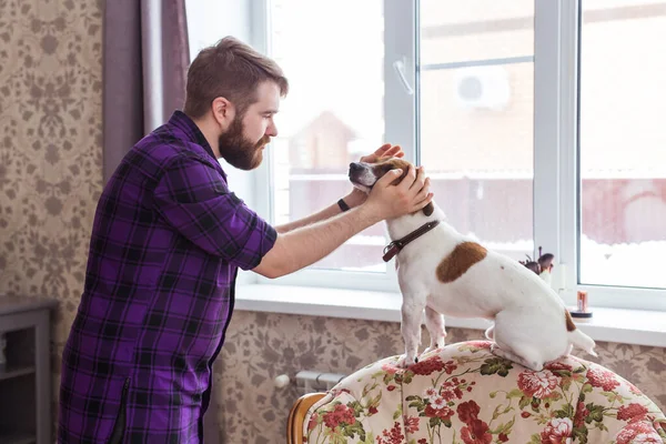 Gros plan portrait beau jeune homme hipster joue et aime son bon ami chien à la maison. Émotions humaines positives, expression faciale, sentiments . — Photo