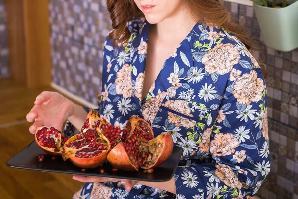 Mulher segura granada vermelha madura grande. Frutas de romã madura vermelha no peitoril das janelas. Vegetariano, vitaminas orgânicas, desintoxicação, conceito de dieta. Frutas de granada orgânicas e benéficas . — Fotografia de Stock