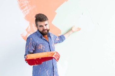 Evin içini boyayan komik adam. Yenileme, onarım ve yeniden dekorasyon konsepti.