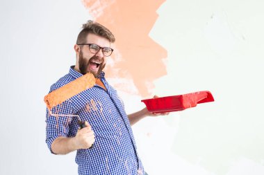 Evin içini boyayan komik adam. Yenileme, onarım ve yeniden dekorasyon konsepti.