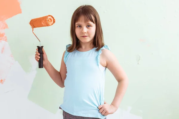 Ragazzo in piedi con il rullo di vernice in mano. Sta dipingendo il muro. Ridecorazione, riparazione e riverniciatura concetto . — Foto Stock