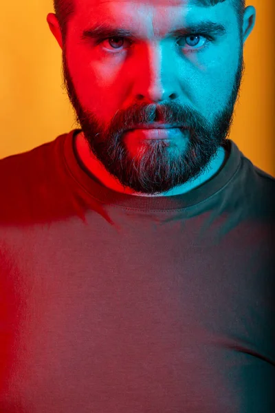 Neon light studio ritratto di attraente modello maschile con baffi e barba indossa t-shirt, primo piano . — Foto Stock