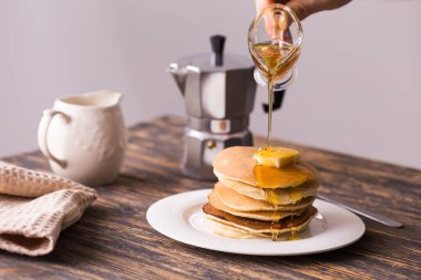 Erkek eli lezzetli kreplere akçaağaç pekmezi döküyor..