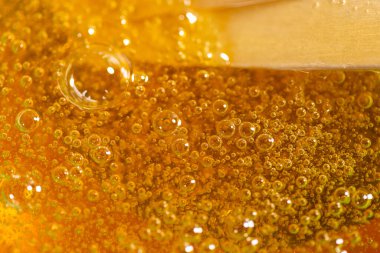 Yakın plan şekerleme için sıvı sarı macun. Saç çıkarma ve tüy dökme konsepti. Makro fotoğrafçılık.