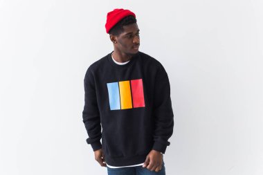 Beyaz arka planda siyah kazak giyen yakışıklı Afro-Amerikan bir adam. Afro saçlı genç sokak modası fotoğrafı..