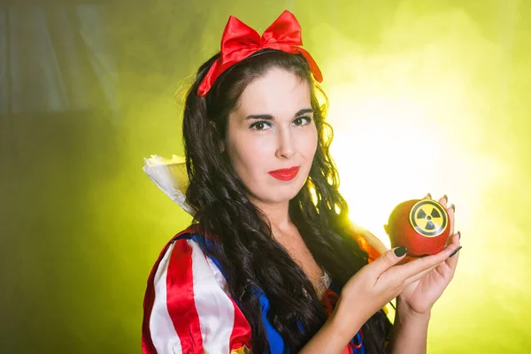 Woman wearing a fairy tale dress holding an apple with radiation symbol. Environmental problems concept, radioactive disaster as danger on nature. — Stock Photo, Image