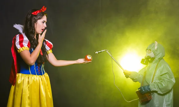 Mulher vestida como personagem de conto de fadas detém Radioactive nuclear radiação ionizante símbolo de perigo de radiação na maçã. Conceito de medição nuclear e de radiação . — Fotografia de Stock