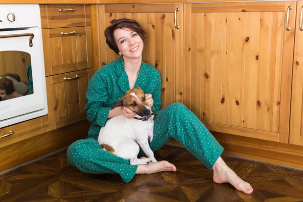 Młoda kobieta z uroczym psem Jackiem Russellem Terrierem siedzącym na podłodze. Zwierzęta i koncepcja domu. Zostań w domu.. — Zdjęcie stockowe