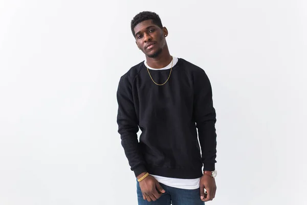 Handsome African American man posing in black sweatshirt on a white background with copyspace. Youth street fashion photo with afro hairstyle. — Stock Photo, Image