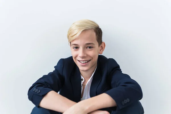 Närbild av tonåring pojke med hängslen på tänderna ler på vit bakgrund. Tandvård och tonårsidé. — Stockfoto