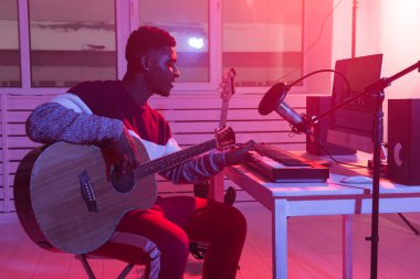 Müzisyen ve müzik yapma konsepti - Afrikalı Amerikalı erkek ses yapımcısı kayıt stüdyosunda çalışıyor.