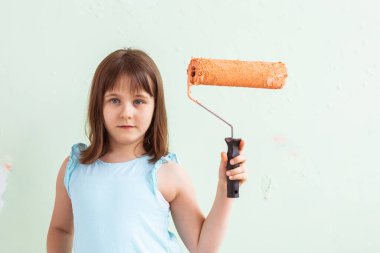 Tadilat duvarını boyayan küçük bir çocuk. Dekorasyon, onarım ve yeniden boyama kavramı.