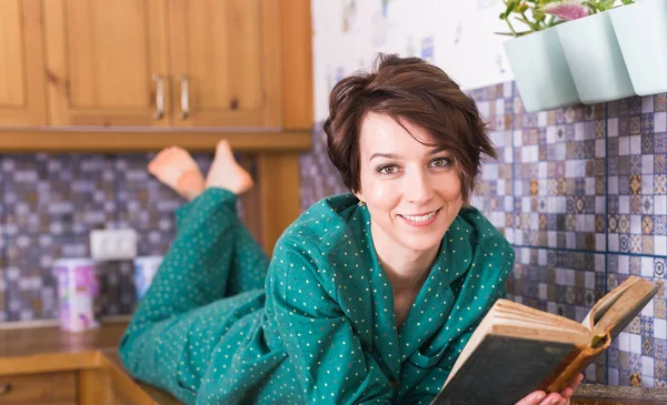 행복 한 여자는 파자마를 입고 집에서 휴식을 취하고 책을 읽는다. 집에 있어. 판 역류 성 코로나 바이러스 개념. — 스톡 사진
