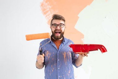 Yeni evin içini boyayan komik adam. Dekorasyon, yenileme, apartman onarımı ve ferahlatıcı konsept.