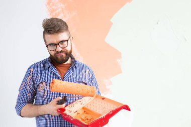 Yeni evin duvarlarını boyayan komik adam. Yenileme, onarım ve dekorasyon konsepti. Boşluğu kopyala.