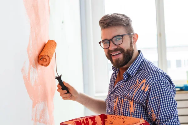 Az ember, aki az új otthon falait festi. Felújítási, javítási és felújítási koncepció. — Stock Fotó