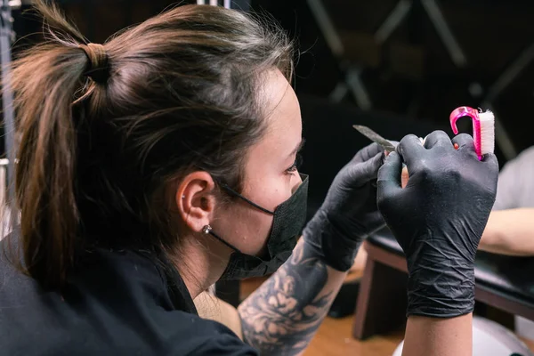 女性のマスターは、サロンでマニキュア中にネイルポリッシュを削除するために電気機械を使用しています。クローズアップハードウェアマニキュア。手のケアの概念。フライス盤による爪の女性マニキュリストのクリーニング — ストック写真