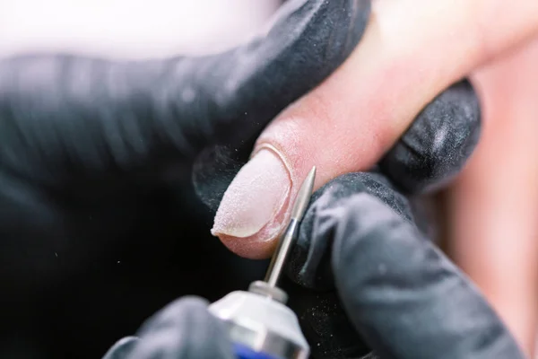 Manicurista utilizzare lima elettrica trapano nel salone di bellezza. Perfetta manicure unghie processo da vicino con scoppiare detriti volanti. — Foto Stock