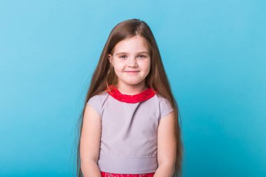 Mavi arka planda izole edilmiş güzel küçük bir kız. Çocukluk ve çocuk kavramı.
