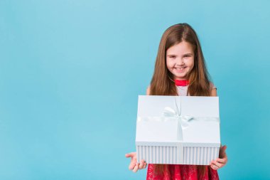 Mutlu çocuk mavi arka planda doğum günü hediyeleri tutuyor. Noel zamanı. Çocukların doğum günü.